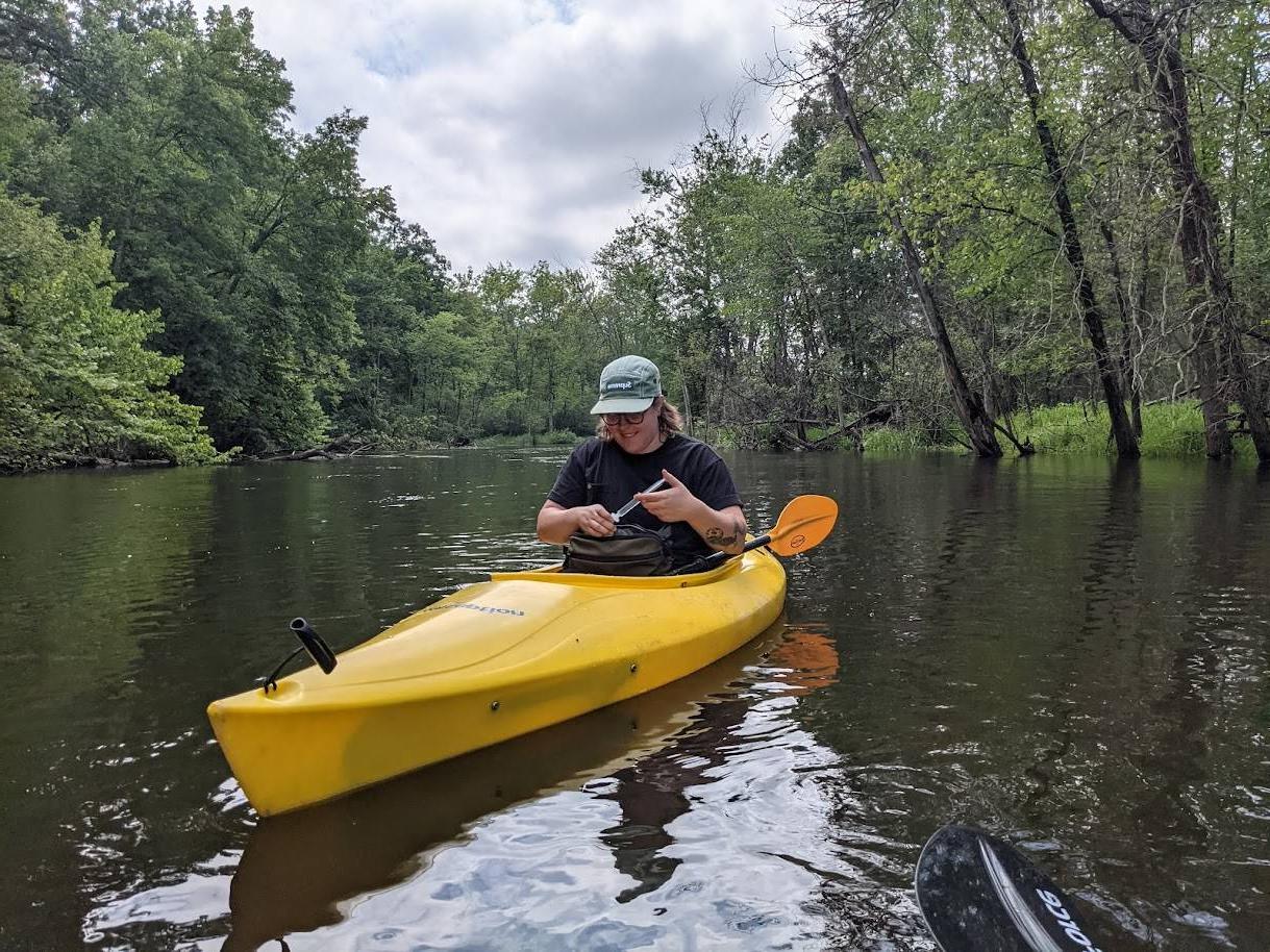 Photo of person in kayak collecting water samples